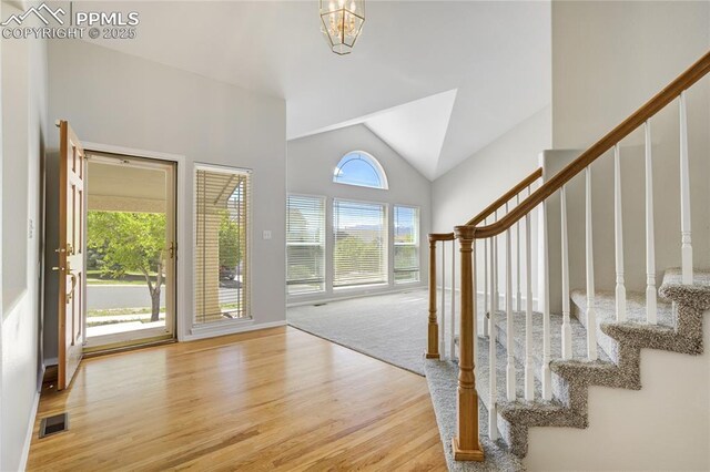 1264 Castle Hills Pl, Colorado Springs, CO 80921 - foyer entrance featuring wood finished floors, stairway, vaulted ceiling, and a chandelier