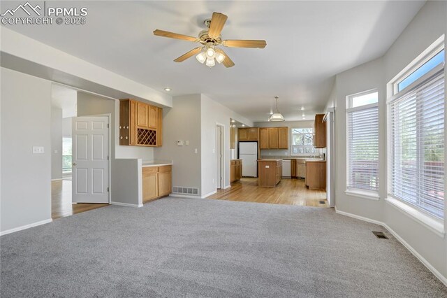 1264 Castle Hills Pl, Colorado Springs, CO 80921 - unfurnished living room featuring light carpet, baseboards, and ceiling fan