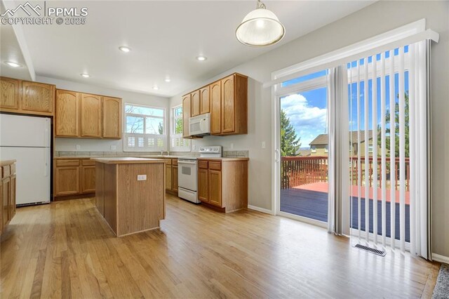 1264 Castle Hills Pl, Colorado Springs, CO 80921 - kitchen featuring white appliances, light wood-type flooring, light countertops, a kitchen island, and recessed lighting