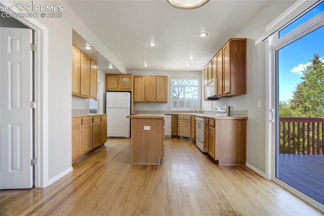 1264 Castle Hills Pl, Colorado Springs, CO 80921 - kitchen with white appliances, light wood-type flooring, a kitchen island, recessed lighting, and baseboards