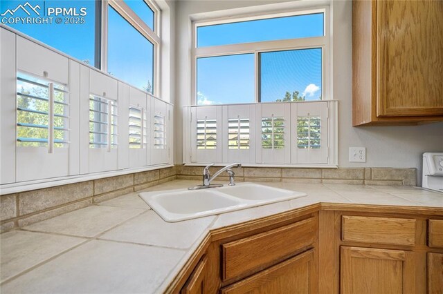 1264 Castle Hills Pl, Colorado Springs, CO 80921 - kitchen with a sink, plenty of natural light, and brown cabinets
