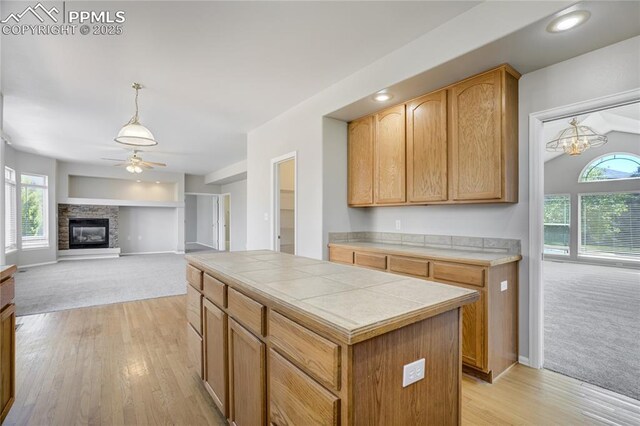 1264 Castle Hills Pl, Colorado Springs, CO 80921 - kitchen with tile counters, a ceiling fan, light carpet, light wood finished floors, and recessed lighting