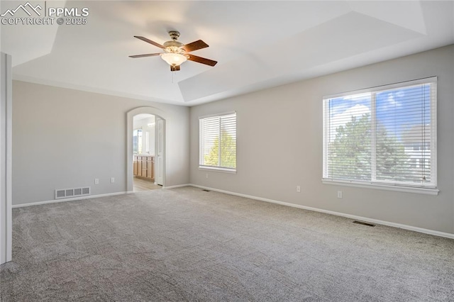 1264 Castle Hills Pl, Colorado Springs, CO 80921 - unfurnished room featuring a tray ceiling, ceiling fan, arched walkways, and carpet