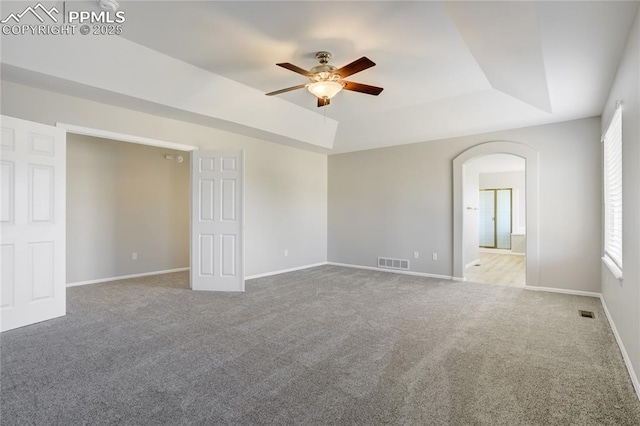 1264 Castle Hills Pl, Colorado Springs, CO 80921 - carpeted empty room featuring a ceiling fan, a raised ceiling, baseboards, and arched walkways