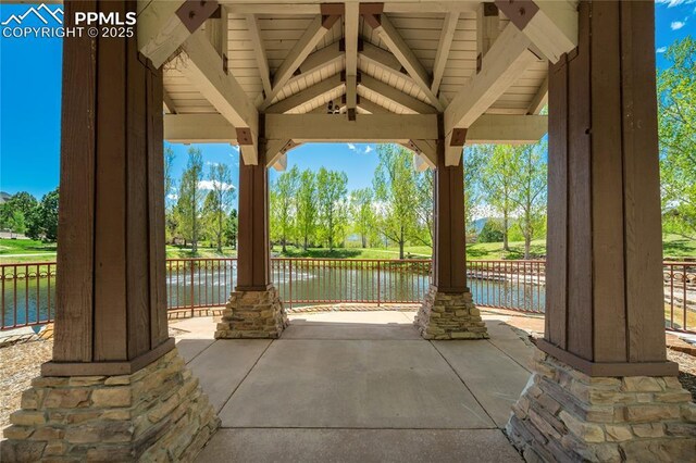 1264 Castle Hills Pl, Colorado Springs, CO 80921 - view of patio / terrace featuring a water view, view of wooded area, and fence