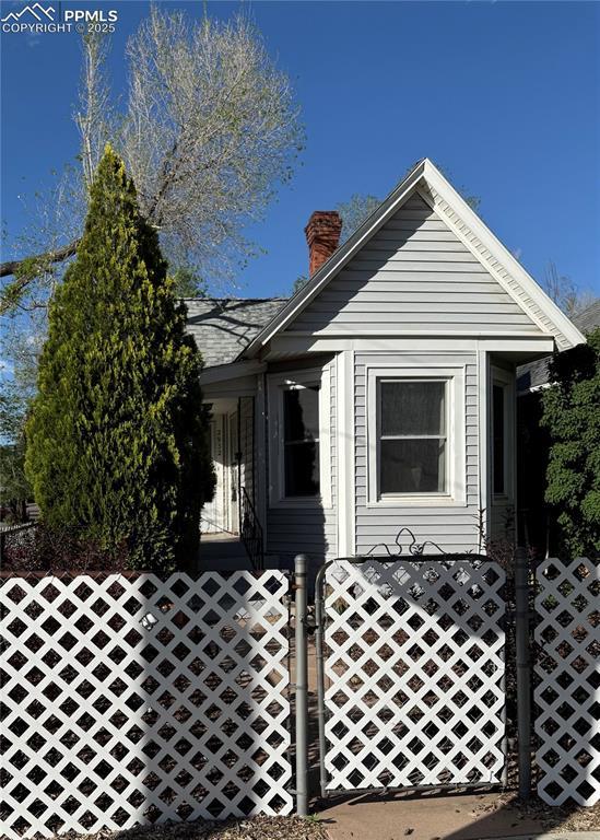 2932 W Kiowa St, Colorado Springs, CO 80904 - view of property exterior with a gate, fence, and a chimney