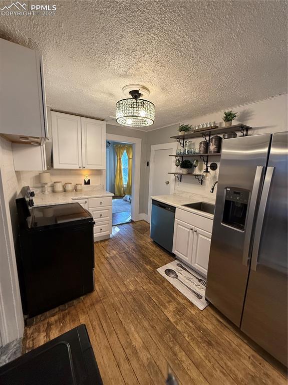 2932 W Kiowa St, Colorado Springs, CO 80904 - kitchen featuring stainless steel fridge, black range with electric cooktop, dishwashing machine, white cabinets, and a textured ceiling
