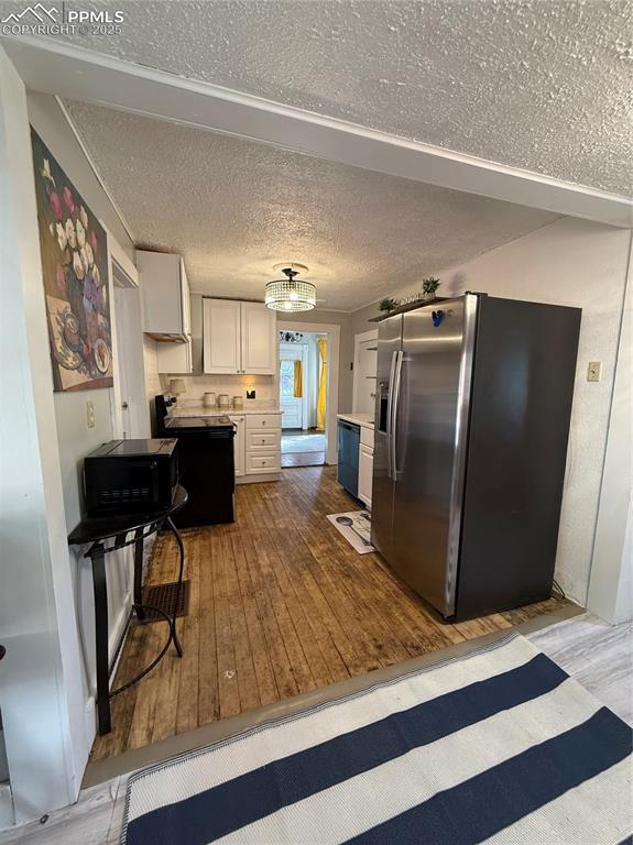 2932 W Kiowa St, Colorado Springs, CO 80904 - kitchen featuring stainless steel refrigerator with ice dispenser, wood-type flooring, dishwasher, white cabinets, and light countertops