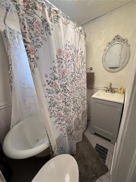 2932 W Kiowa St, Colorado Springs, CO 80904 - full bathroom featuring vanity and shower / tub combo with curtain