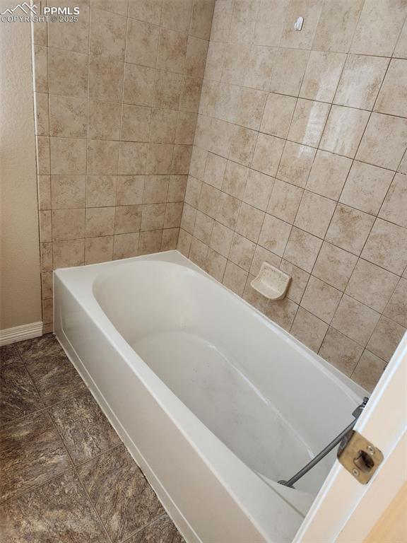 6282 Pilgrimage Rd, Colorado Springs, CO 80925 - full bathroom featuring a bath and baseboards