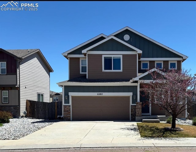 6282 Pilgrimage Rd, Colorado Springs, CO 80925 - craftsman-style home featuring board and batten siding, fence, a garage, concrete driveway, and stone siding