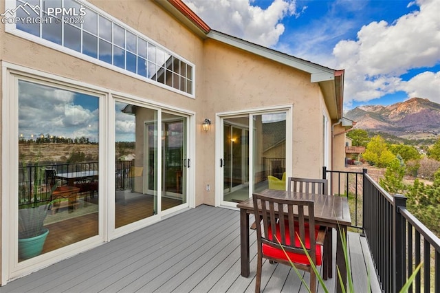 wooden deck featuring a mountain view and outdoor dining area
