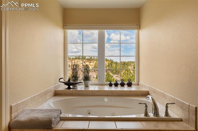 full bath featuring a textured wall and a whirlpool tub