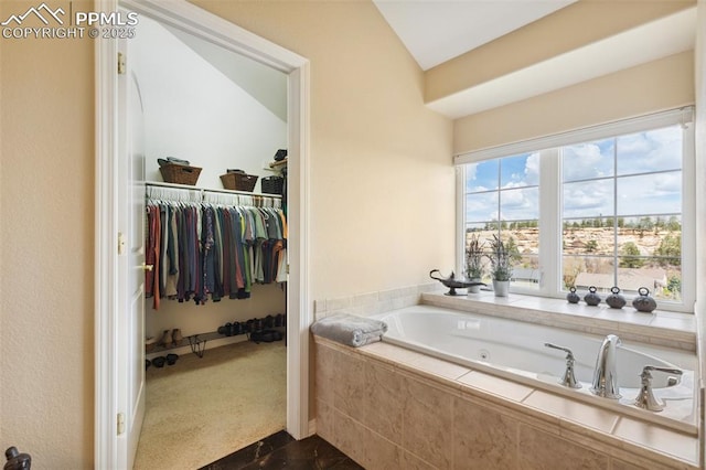 full bath with a bath, a walk in closet, and lofted ceiling