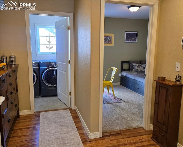 laundry area featuring washer and dryer, wood finished floors, and baseboards