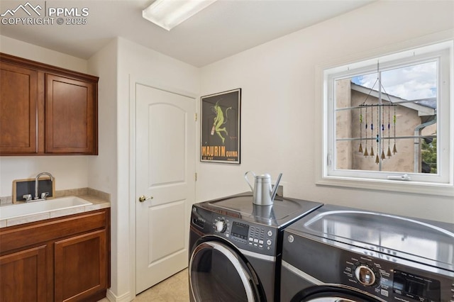 laundry room featuring washer and dryer, cabinet space, and light tile patterned flooring
