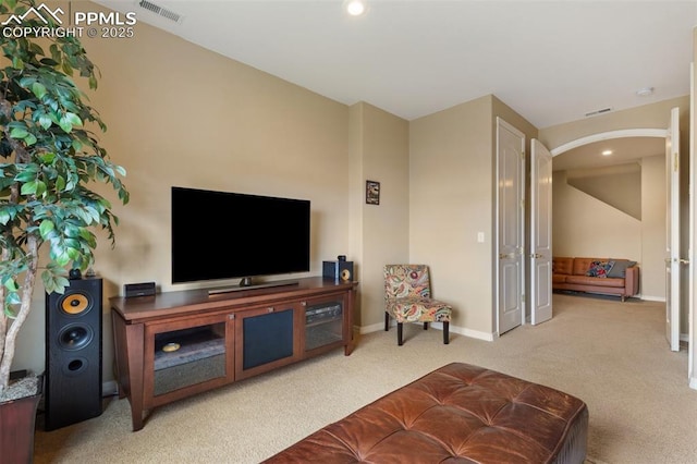 living room featuring arched walkways, carpet floors, baseboards, and recessed lighting