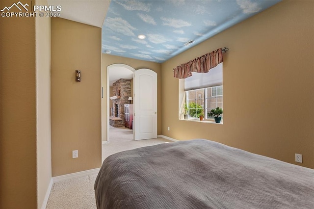 bedroom featuring carpet, arched walkways, and baseboards