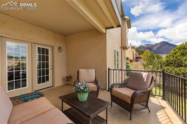 balcony featuring a mountain view, outdoor lounge area, and french doors