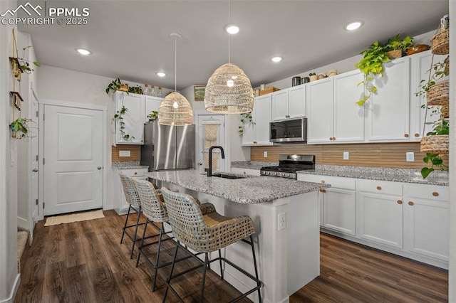 7907 Tremble Pt, Colorado Springs, CO 80908 - kitchen with a sink, appliances with stainless steel finishes, decorative backsplash, white cabinets, and recessed lighting