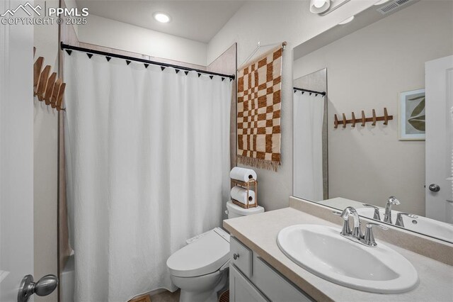 7907 Tremble Pt, Colorado Springs, CO 80908 - full bathroom featuring toilet, vanity, and shower / tub combo with curtain
