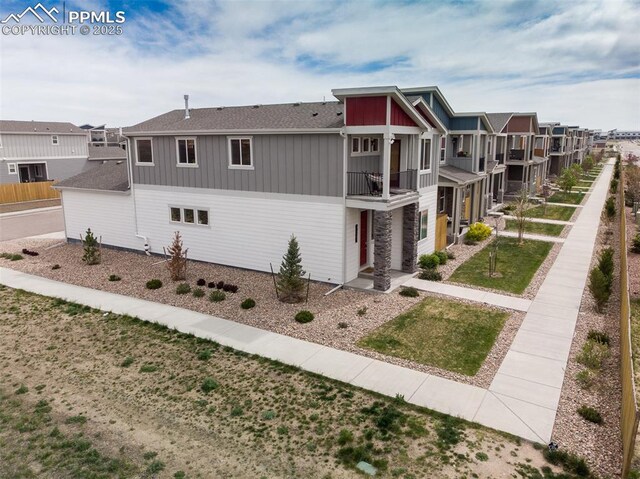 7907 Tremble Pt, Colorado Springs, CO 80908 - view of front facade with board and batten siding, a balcony, a residential view, and roof with shingles