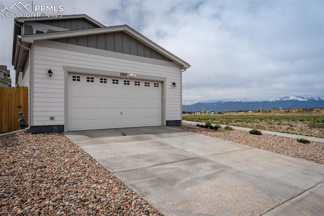 7907 Tremble Pt, Colorado Springs, CO 80908 - garage featuring a mountain view, driveway, and fence