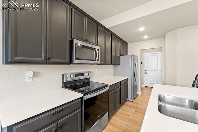 11456 Sanderling St, Colorado Springs, CO 80925 - kitchen featuring appliances with stainless steel finishes, a sink, light wood-style flooring, recessed lighting, and light countertops