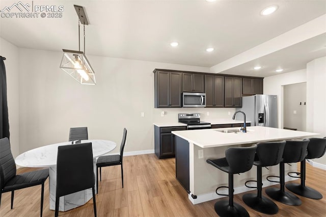 11456 Sanderling St, Colorado Springs, CO 80925 - kitchen featuring appliances with stainless steel finishes, a sink, a kitchen island with sink, recessed lighting, and light wood finished floors