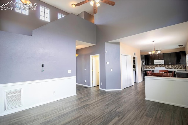 3808 Happy Jack Dr, Colorado Springs, CO 80922 - kitchen featuring white microwave, a chandelier, open floor plan, dark wood-type flooring, and a high ceiling