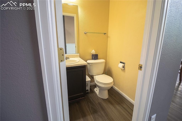 3808 Happy Jack Dr, Colorado Springs, CO 80922 - half bath with wood finished floors, toilet, vanity, a textured wall, and baseboards