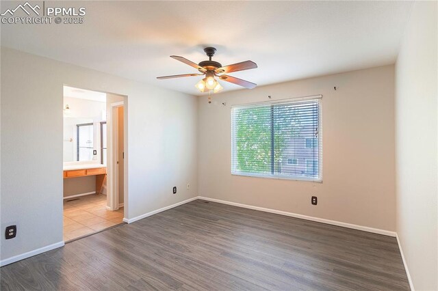 3808 Happy Jack Dr, Colorado Springs, CO 80922 - unfurnished bedroom featuring wood finished floors, baseboards, ensuite bath, and a ceiling fan