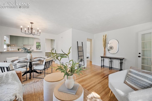 1428 N Prospect St, Colorado Springs, CO 80907 - living room with arched walkways, a chandelier, and light wood-style floors