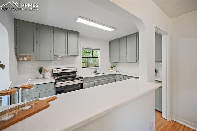 1428 N Prospect St, Colorado Springs, CO 80907 - kitchen featuring electric range, gray cabinets, arched walkways, a sink, and tasteful backsplash