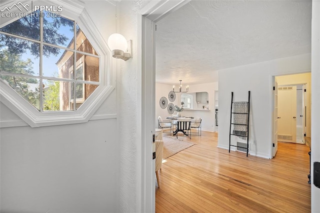 1428 N Prospect St, Colorado Springs, CO 80907 - hall with light wood-style floors, a chandelier, and baseboards
