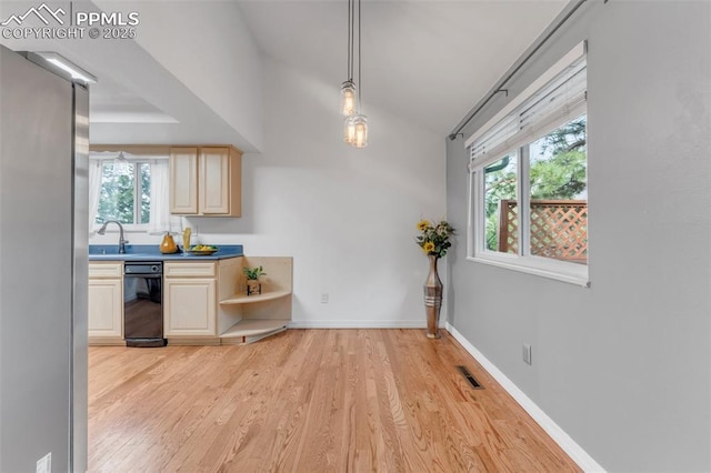 445 Wintery Cir, Colorado Springs, CO 80919 - unfurnished dining area with light wood-style floors, baseboards, vaulted ceiling, and a sink
