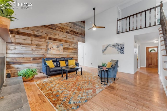 445 Wintery Cir, Colorado Springs, CO 80919 - living area featuring a ceiling fan, high vaulted ceiling, wooden walls, wood finished floors, and baseboards