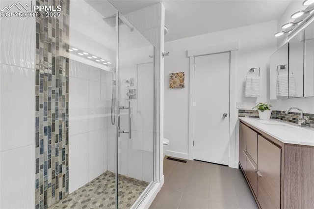 445 Wintery Cir, Colorado Springs, CO 80919 - full bathroom featuring a shower stall, vanity, toilet, and decorative backsplash