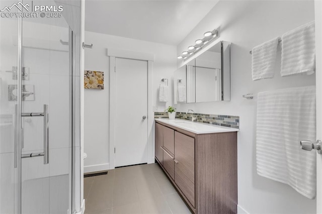 445 Wintery Cir, Colorado Springs, CO 80919 - bathroom featuring vanity, a shower stall, backsplash, and tile patterned floors
