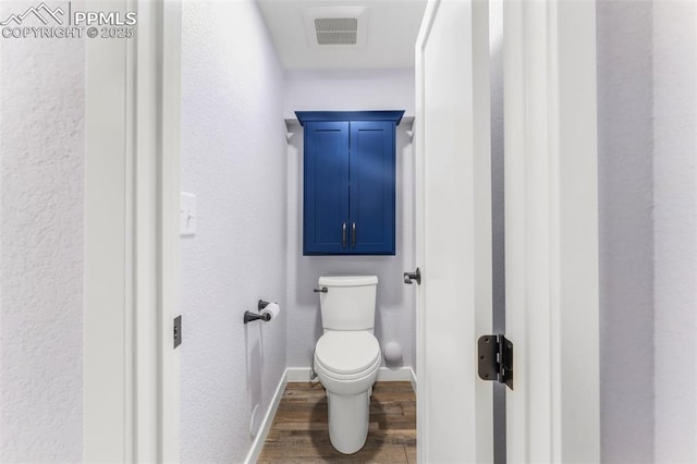 445 Wintery Cir, Colorado Springs, CO 80919 - bathroom with wood finished floors, toilet, baseboards, and a textured wall