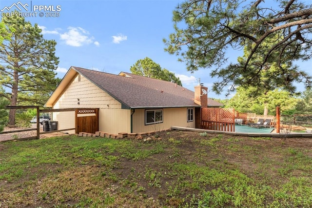 445 Wintery Cir, Colorado Springs, CO 80919 - back of property featuring a chimney, roof with shingles, and central AC