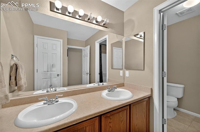 7470 Sandy Springs Pt, Fountain, CO 80817 - bathroom featuring toilet, double vanity, baseboards, and tile patterned floors