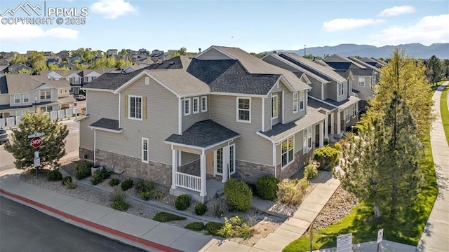 7470 Sandy Springs Pt, Fountain, CO 80817 - view of side of home featuring stone siding, a residential view, a mountain view, and a shingled roof