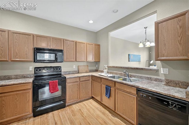 7470 Sandy Springs Pt, Fountain, CO 80817 - kitchen featuring black appliances, a sink, light wood-style flooring, a chandelier, and light countertops