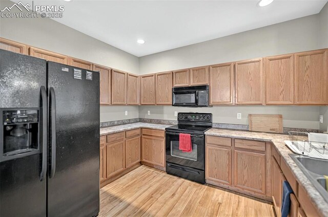 7470 Sandy Springs Pt, Fountain, CO 80817 - kitchen with black appliances, light wood-type flooring, light countertops, a sink, and recessed lighting
