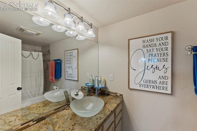 921 Cottonwood Lake Dr, Divide, CO 80814 - full bath featuring a shower with shower curtain, a textured wall, and vanity