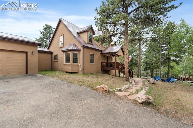 921 Cottonwood Lake Dr, Divide, CO 80814 - view of side of home with metal roof, stucco siding, asphalt driveway, an attached garage, and a standing seam roof