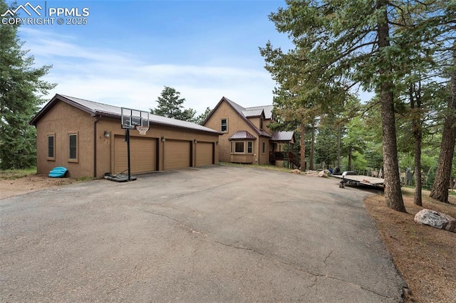 921 Cottonwood Lake Dr, Divide, CO 80814 - view of property exterior with metal roof, a garage, a standing seam roof, stucco siding, and an outbuilding