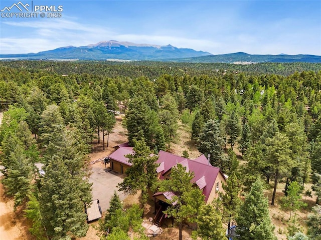 921 Cottonwood Lake Dr, Divide, CO 80814 - drone / aerial view of a heavily wooded area and a mountain backdrop