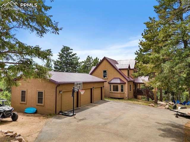 921 Cottonwood Lake Dr, Divide, CO 80814 - view of front of home with stucco siding, an attached garage, and metal roof